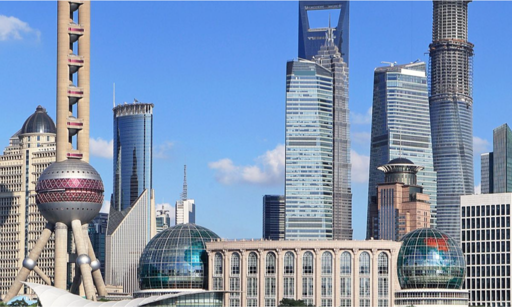 The distinctive pink spheres of the Oriental Pearl Tower set against a clear blue sky alongside the modern skyscrapers of the Lujiazui financial district during a luxury private tour of Shanghai with Lux Orient.