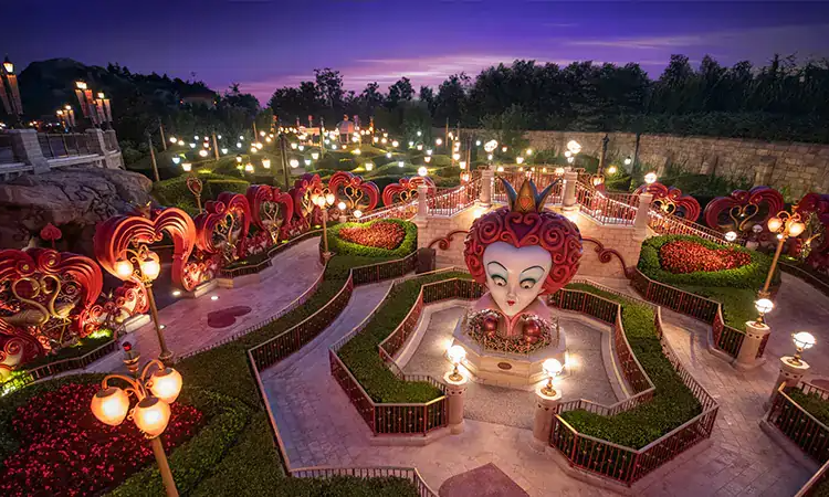 A panoramic twilight view of an illuminated theme park garden at Shanghai Disney Resort, highlighting the premium, all-inclusive private VIP concierge tour packages offered by Lux Orient.