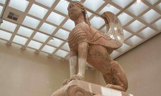 The ancient marble Sphinx of Naxos displayed on a pedestal inside a well-lit gallery at the Delphi Archaeological Museum during a luxury private Athens history tour with Lux Orient.