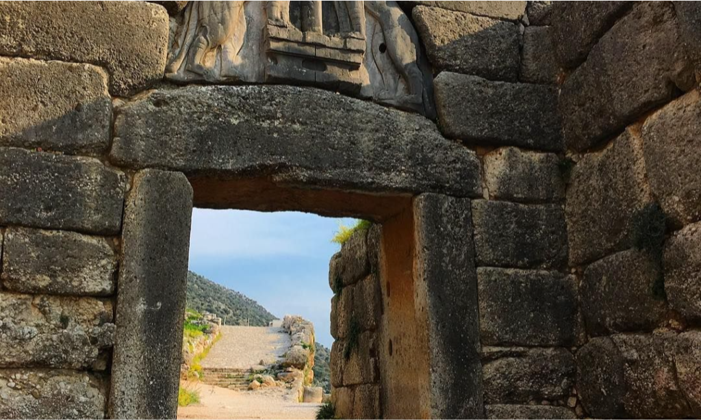 The ancient megalithic stone blocks and carved relief of the Lion Gate at the citadel of Mycenae during an exclusive bespoke luxury tour departing from Athens with Lux Orient.