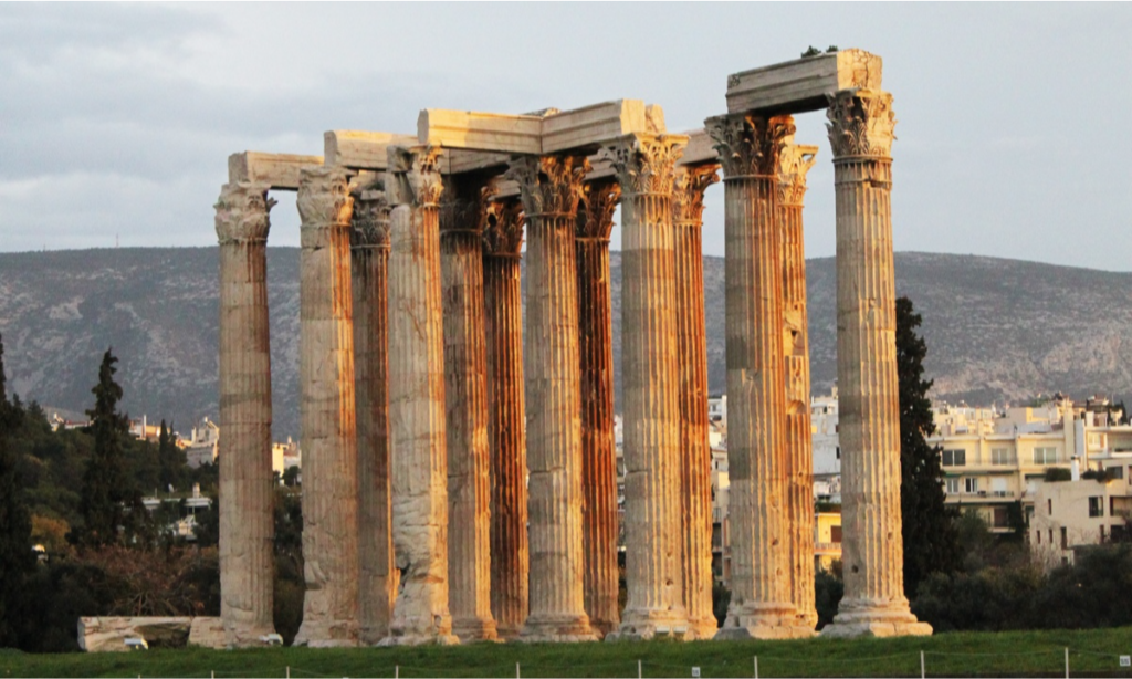 The massive remaining fluted Corinthian columns and stone architraves of the ancient Temple of Olympian Zeus in Athens glowing during a luxury private cultural tour with Lux Orient.