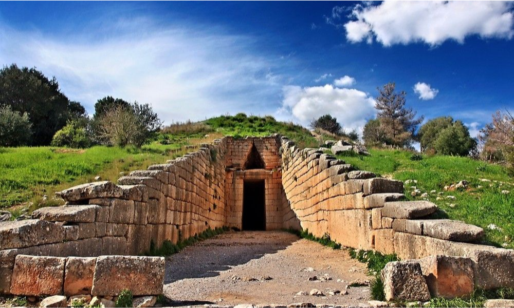 The monumental stone-walled entrance pathway and triangular lintel of the ancient Treasury of Atreus beehive tomb in Mycenae during an exclusive private heritage excursion from Athens with Lux Orient.