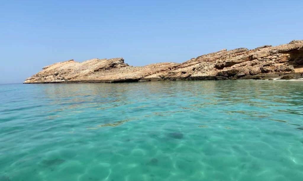 A high-angle panoramic view of the crescent-shaped luxury marina and beach resort at Al Musannah, Oman, during a private VIP coastal sailing tour with Lux Orient.