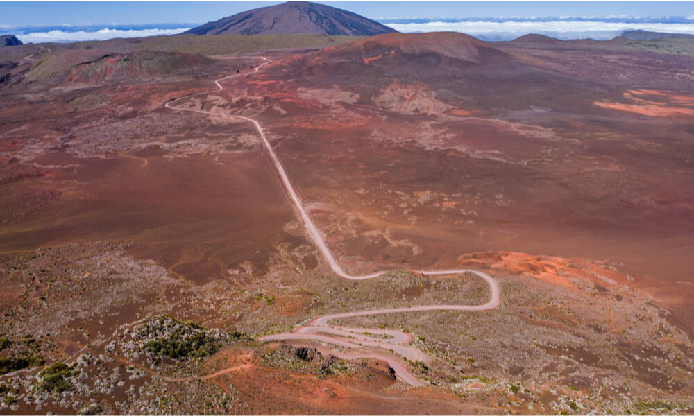 The massive volcanic crater and dark, textured basaltic lava fields of Piton de la Fournaise under a dramatic sky in La Réunion, during an exclusive private luxury tour with Lux Orient.