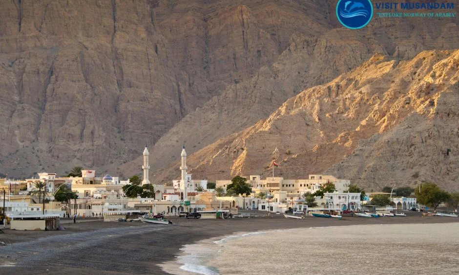 Traditional stone houses and narrow alleyways of Limah Village nestled beneath the towering, rugged Hajar Mountains in Musandam, Oman, during an elite private luxury heritage tour with Lux Orient.