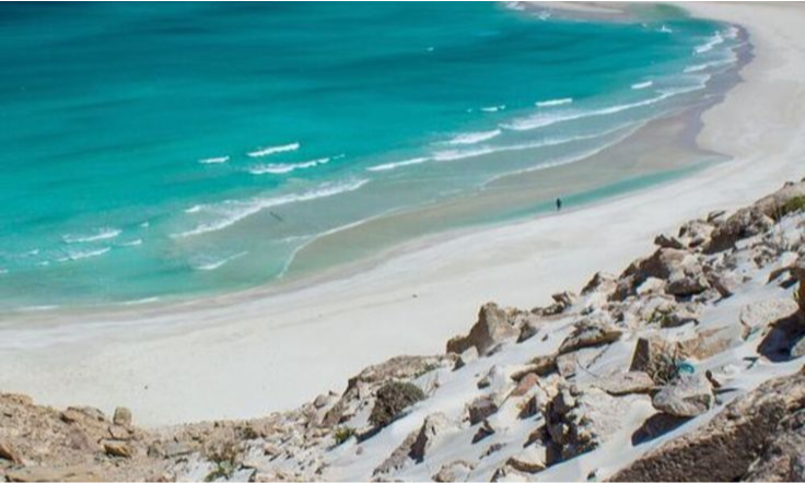 The sweeping white sandbar and vibrant turquoise waters of Detwah Lagoon under a clear blue sky on Socotra Island, Yemen, during an exclusive private luxury tour with Lux Orient.