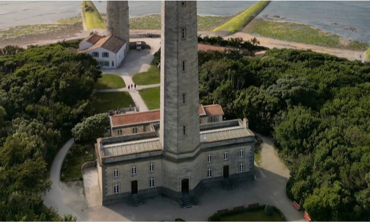 The classic white masonry tower of the historic Phare de Bel-Air lighthouse standing against a bright blue sky on the lush coastal headland of Sainte-Suzanne, La Réunion, during an exclusive private luxury tour with Lux Orient.