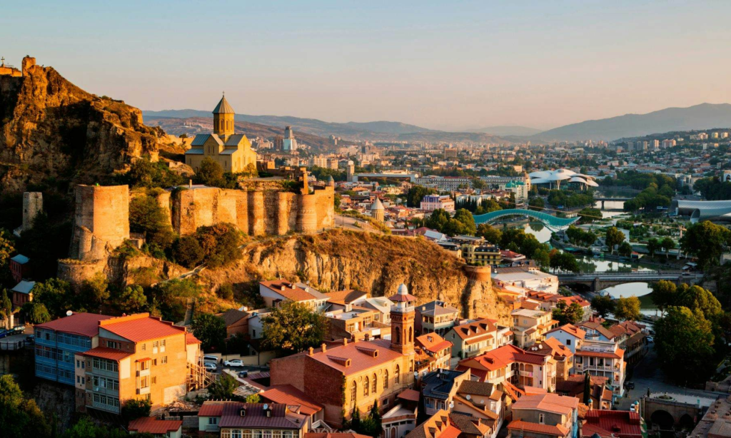 The ancient stone fortress walls and watchtowers of Narikala Fortress overlooking the panoramic city skyline and historic brick buildings of Old Tbilisi, Georgia, during an exclusive private luxury tour with Lux Orient.