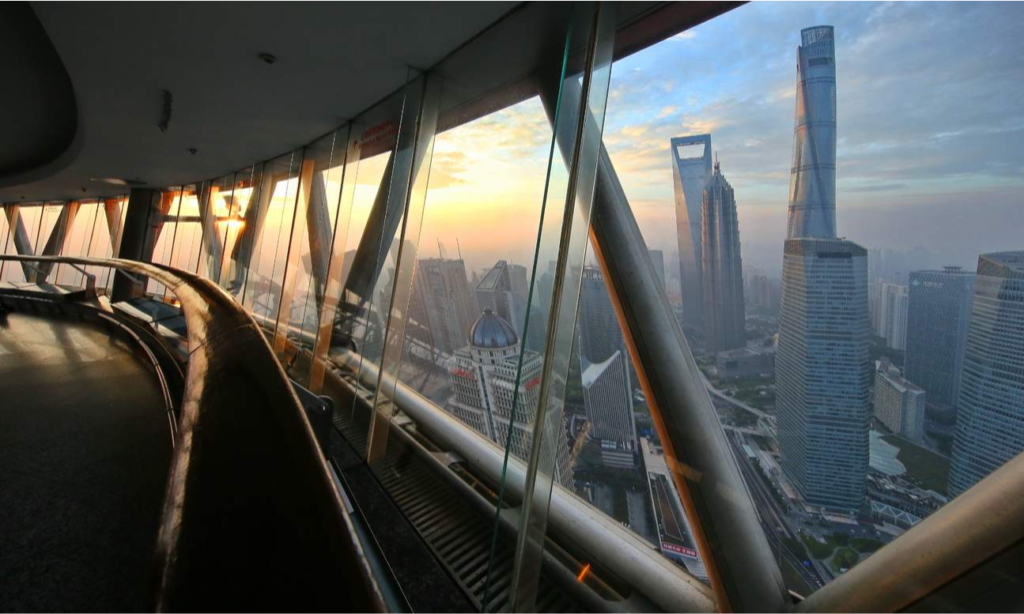 The distinctive futuristic spheres and soaring architectural pillars of the Oriental Pearl Tower glowing against the evening sky in Pudong, Shanghai, during an exclusive private luxury tour with Lux Orient.
