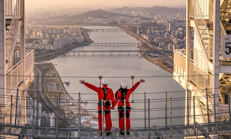 A breathtaking bird's-eye view looking down through the glass floor of the Seoul Sky Observatory at the expansive Han River and Seoul cityscape in South Korea during a luxury private tour with Lux Orient.