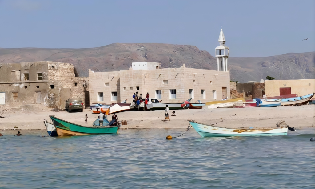 Traditional stone houses and wooden fishing boats lining the sandy coast of Qalansiyah Fisherman Town on Socotra Island, Yemen, during an elite private luxury cultural tour with Lux Orient.