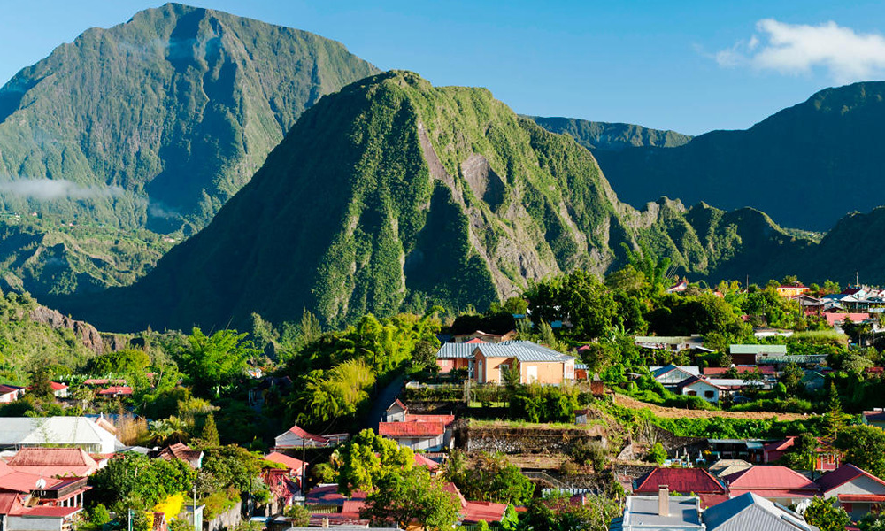 The colorful timber facades, ornamental lambrequins, and lush tropical gardens of a historic nineteenth-century Creole villa in the mountain village of Hell-Bourg, La Réunion, during an exclusive private tour with Lux Orient.