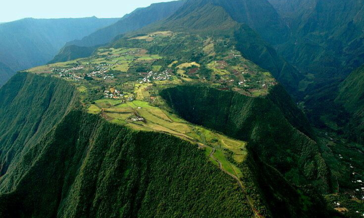 Lush green organic tea fields and winding pathways on the scenic mountain ridge of Grand Coude in Saint-Joseph, La Réunion, during an exclusive private luxury tour with Lux Orient.