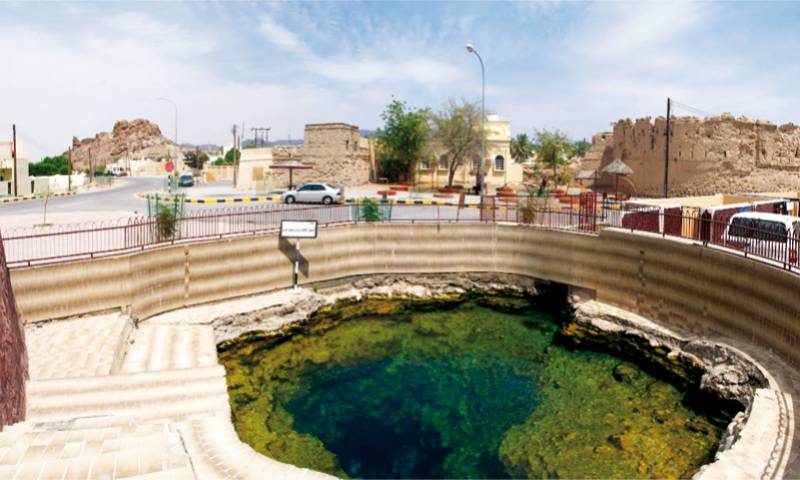 The natural bubbling thermal pools and stone-built channels of the Ain Al Kasfah hot spring in Rustaq, Oman, styled for an elite wellness itinerary including the fjords of Musandam, Oman, with Lux Orient."