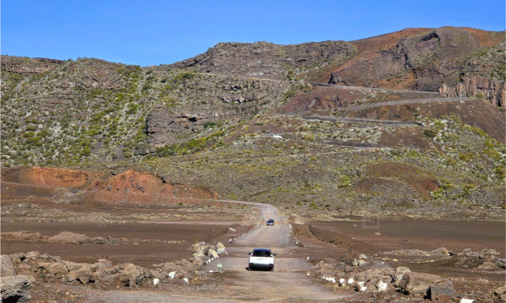 The massive volcanic crater and dark, textured basaltic lava fields of Piton de la Fournaise under a dramatic sky in La Réunion, during an exclusive private luxury tour with Lux Orient.